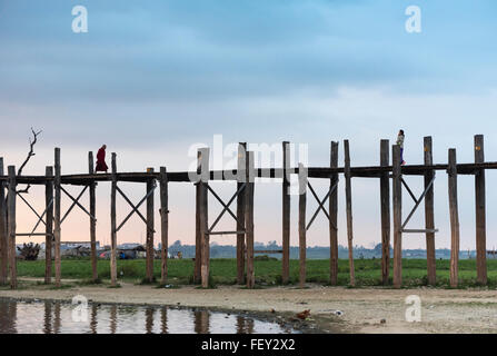 Le moine bouddhiste traverse le pont U Bein - le plus long pont en teck du monde dans Amarapura près de Mandalay, Myanmar (Birmanie Banque D'Images