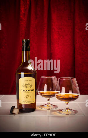 Une bouteille de Calvados pomme de Normandie, France, avec deux verres Banque D'Images