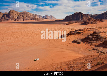 Petite voiture dans un immense désert de Wadi Rum. Tourné à partir de la seule grande dune de sable. Banque D'Images