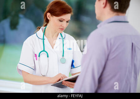 Doctor and nurse discussing notes Banque D'Images