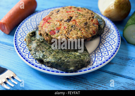Libre de quelques différentes veggie burgers dans une plaque en céramique, sur une table en bois bleu rustique Banque D'Images
