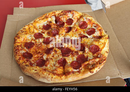 Une pizza au pepperoni, dans sa boîte de carton. Banque D'Images