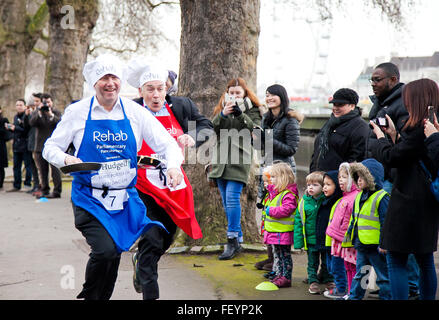 Westminster, Londres, Royaume-Uni. February 9th, 2016 - Course de crêpes parlementaire Rehab 2016 a lieu comme Lord Porter de Spalding CBE et Alastair Stewart OBE, ITV News presenter course contre l'autre tout en le jetant Crédit : crêpes Dinendra Haria/Alamy Live News Banque D'Images