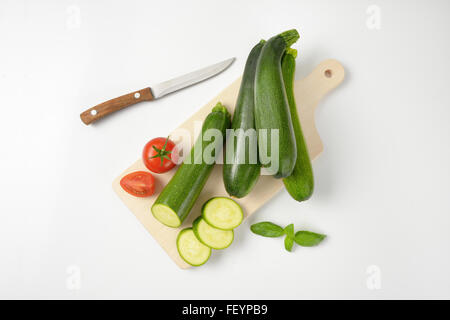 Courgettes et tomates fraîches sur planche à découper en bois Banque D'Images