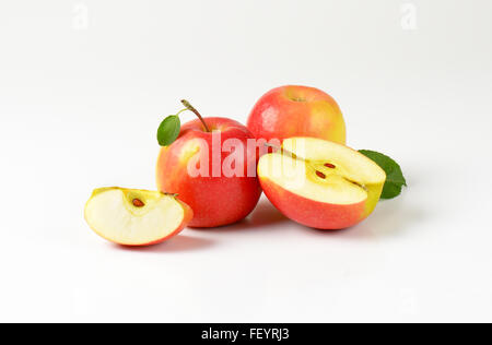 Les pommes entières et tranchées avec des feuilles sur fond blanc Banque D'Images