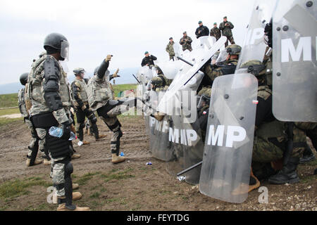 Un soldat de l'Armée américaine affecté à la Compagnie Alpha, 1er Bataillon interarmes, 252ème régiment d'armure, les tentatives visant à perturber une foule polonaise au cours d'une ligne de lutte antiémeute 10 Déc., 2015, l'exercice de formation au Camp Marechal de Lattre de Tassigny, au Kosovo. Le quartier général du bataillon 1-252 est le combat multinationales Group-East Commande Transférer poste au Kosovo, de la supervision de la Compagnie Alpha et soldats polonais, ainsi que les unités d'entreprise de l'Allemagne, la Hongrie et la Slovénie. Banque D'Images