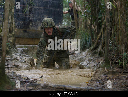 L'Okinawa, Japon (Janv. 12, 2016) Électricien de construction Constructionman Jacob H. Raines, affectés à la construction navale (bataillon Mobile NMCB) 3, combat dans la boue à hauteur du genou et de l'eau lors de l'exécution d'un programme de six heures de cours à la Marine Corps Jungle Warfare Training Center (ETFC). 3 NMCB est déployée sur plusieurs pays de la zone d'opérations du Pacifique, la conduite des opérations de construction et les projets d'aide humanitaire. Banque D'Images