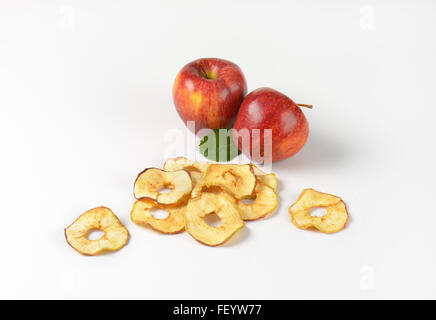 Pommes rouges frais et séchés apple rings sur fond blanc Banque D'Images
