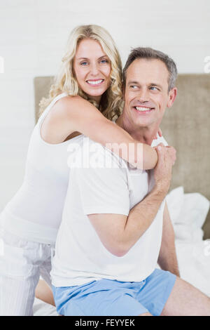 Cute couple cuddling in bed Banque D'Images