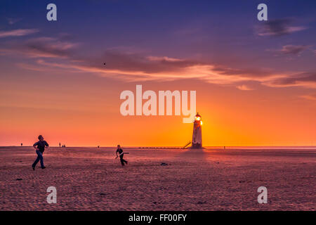 Jouer beach cricket sur plage de Talacre au coucher du soleil. Banque D'Images