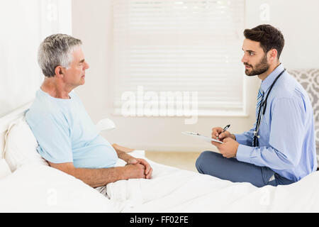 Infirmière beau la visite d'un homme mûr Banque D'Images