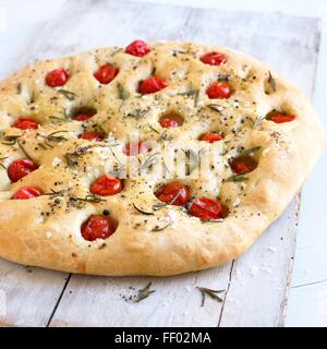 Focaccia pain garni avec les tomates cerises et les branches de romarin Banque D'Images