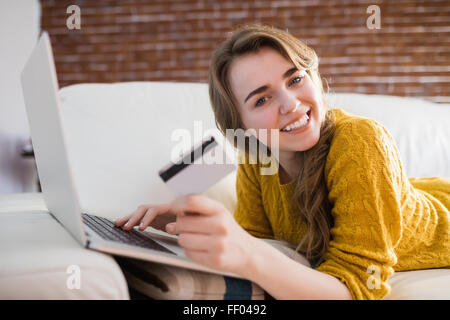Jeune femme en utilisant sa carte de crédit pour acheter en ligne Banque D'Images