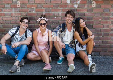 Amis de la hanche assis sur le plancher Banque D'Images