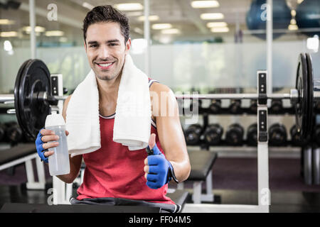 Smiling man showing thumb up et tenant une bouteille d'eau Banque D'Images