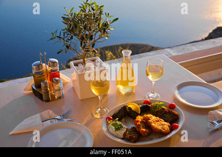 Dîner romantique pour deux au coucher du soleil.La Grèce, Santorin, restaurant sur la plage, au-dessus du volcan. La vue du sommet. Banque D'Images