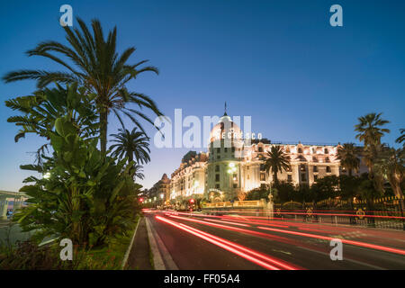 L'hôtel Negresco sur la Promenade des Anglais à Nice, de palmiers, de la circulation, crépuscule, Provence-Alpes-Côte d'Azur, France Banque D'Images