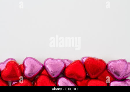 Chocolats en forme de coeur alignés sur le bord inférieur de l'image. Décoration valentine candy organisé dans la partie inférieure du cadre. Banque D'Images