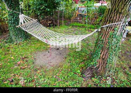 Maille confortable hamac entre deux arbres dans un jardin vert Banque D'Images