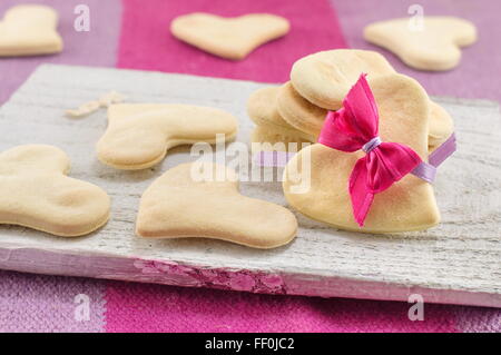 Des biscuits en forme de coeur sur une planche à découper Banque D'Images