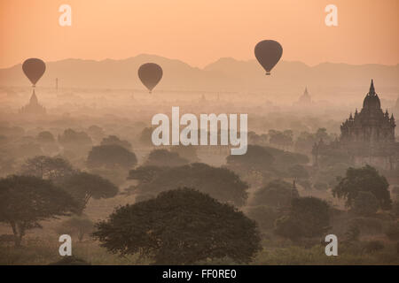 Ballons volent sur les temples de Bagan, Myanmar au lever du soleil Banque D'Images