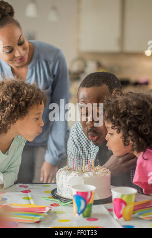 Soufflage des bougies d'anniversaire père at party Banque D'Images