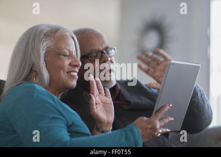 Vieux couple chat vidéo with digital tablet Banque D'Images