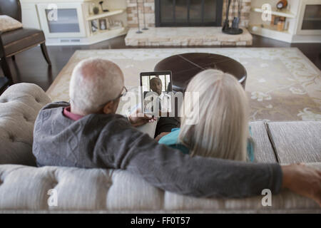 Vieux couple chat vidéo with digital tablet Banque D'Images