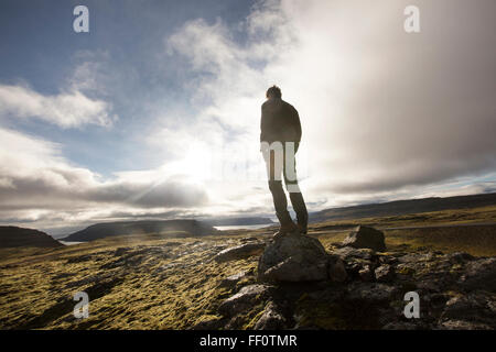 Caucasian man standing on rock in field Banque D'Images