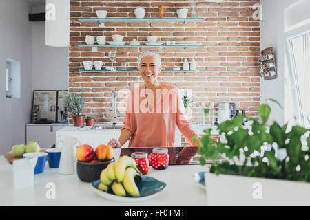 Older Caucasian woman smiling in kitchen Banque D'Images