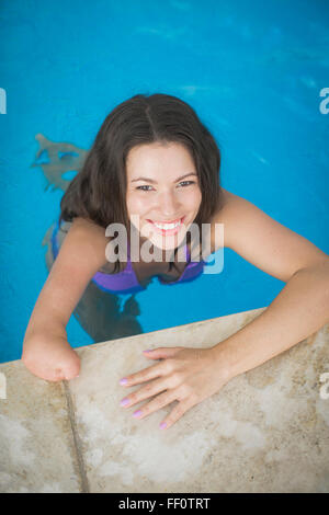 Mixed Race woman swimming in pool amputé Banque D'Images