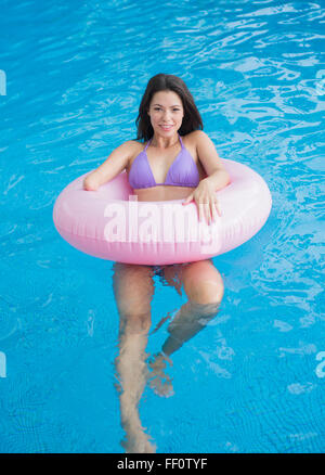 Mixed Race woman swimming in pool amputé Banque D'Images