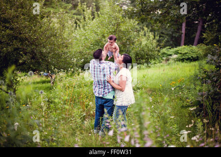 Les parents holding baby in garden Banque D'Images