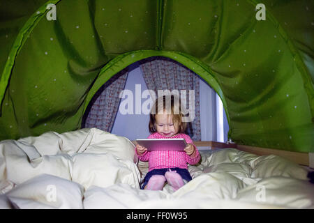 Caucasian baby girl using digital tablet in tent Banque D'Images