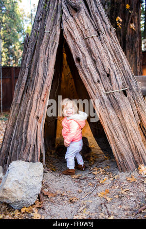 Caucasian baby girl playing en tipi Banque D'Images