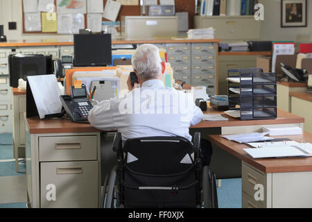 Caucasian businessman talking on phone in office Banque D'Images