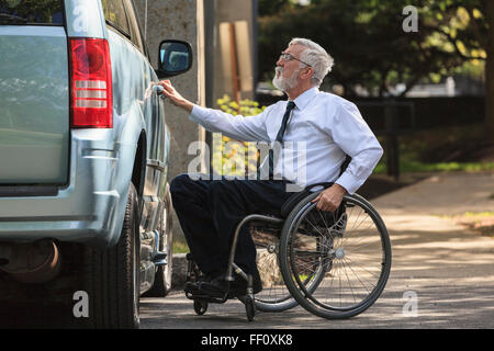 Caucasian businessman en ouverture de porte en fauteuil roulant van Banque D'Images