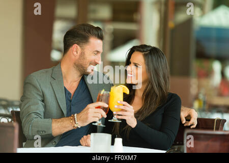 Couple toasting with cocktails at restaurant Banque D'Images