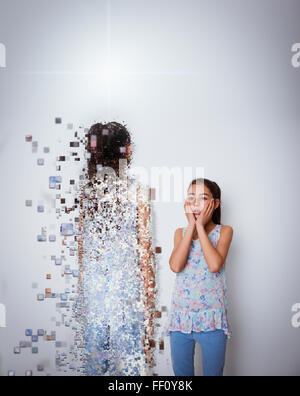 Mixed Race girl with digital projection d'elle-même Banque D'Images