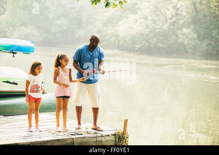 Père et filles la pêche dans le lac Banque D'Images