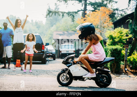 Girl riding moto miniature on street Banque D'Images