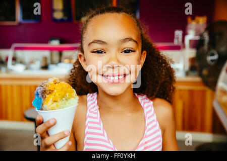 Mixed Race girl holding snow cone Banque D'Images