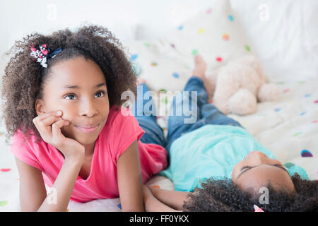 Mixed Race girl laying on bed Banque D'Images