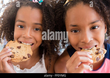 Mixed Race girl eating cookies Banque D'Images