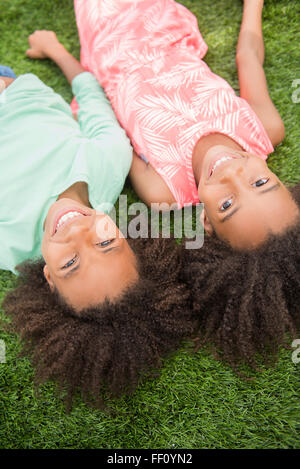 Mixed Race girl laying in grass Banque D'Images