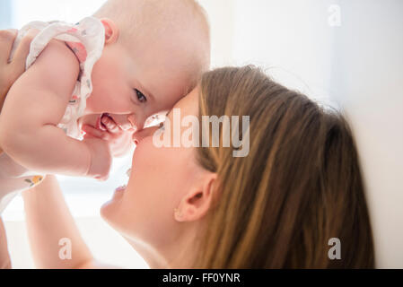 Caucasian mother holding baby daughter