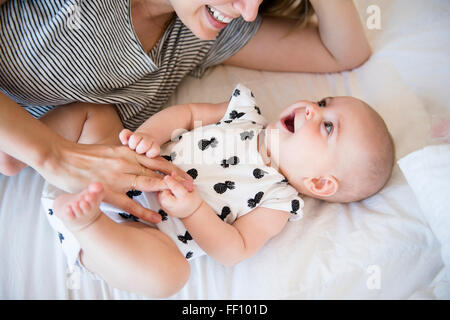 Mère et fille bébé caucasien portant sur le lit Banque D'Images