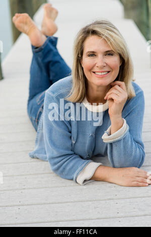 Older Caucasian woman laying on pier Banque D'Images