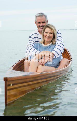 Caucasian couple hugging in canoe Banque D'Images