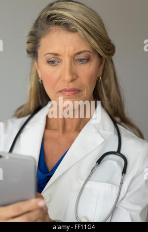 Caucasian doctor using cell phone Banque D'Images